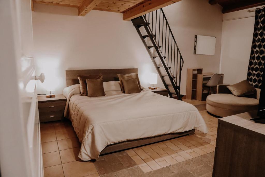 una camera con un grande letto e una scala di Appartamento - Grammichele Privitera rooms & apartments Gold a Grammichele