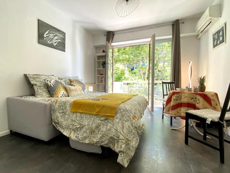 une chambre avec un lit, une table et une fenêtre dans l'établissement Studio balcon, centre ville, proximité plages, commerces, restaurants, musées..., à Antibes