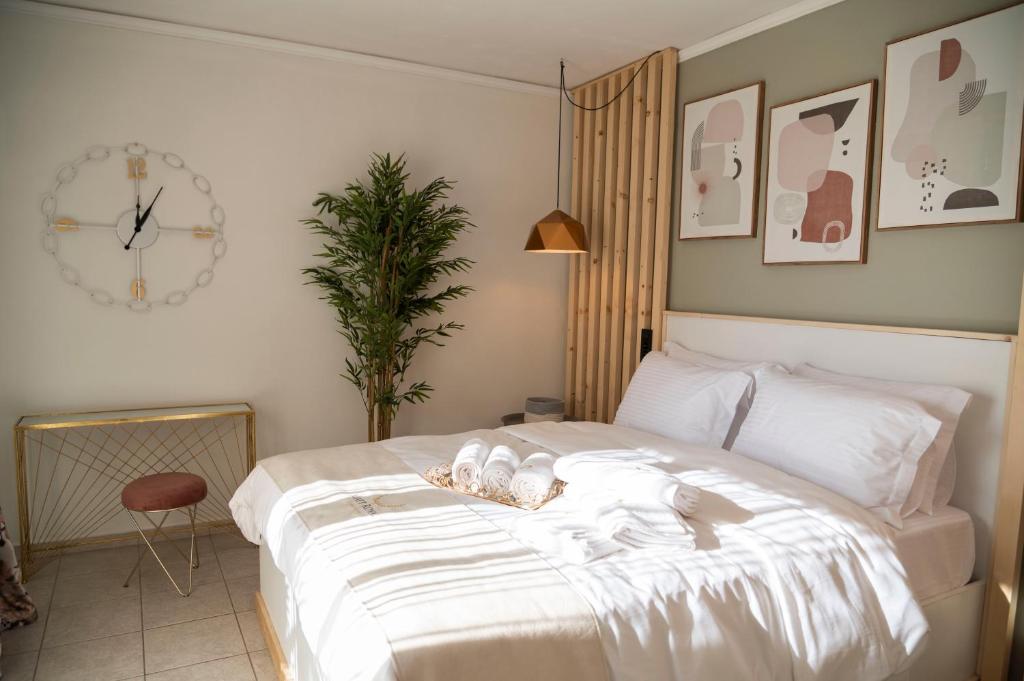 1 dormitorio con 1 cama blanca y reloj en la pared en SeaView Luxury Suite, en Alexandroupoli