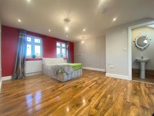 a living room with a bed and a wooden floor at Massive Studio with Garden In Leafy Canary Wharf Docklands Retreat in London