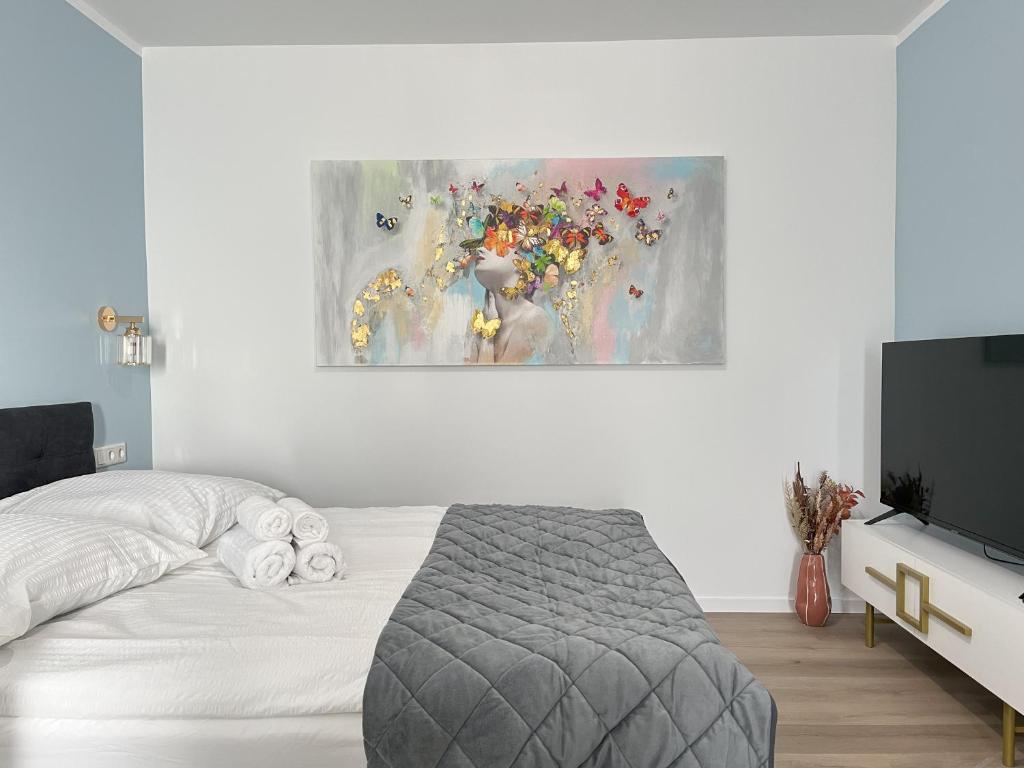 a bedroom with a bed and a painting on the wall at STAYWELL I Südstadt Für 4 I CO2 Free in Paderborn