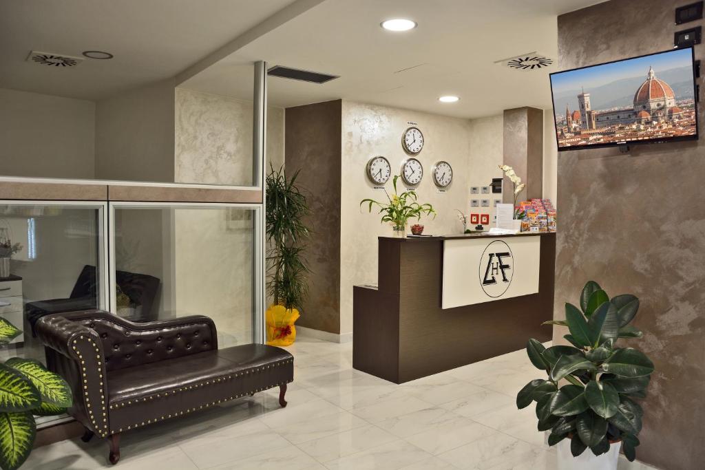 a living room with a leather chair and a tv at Hotel Luxor Florence in Florence