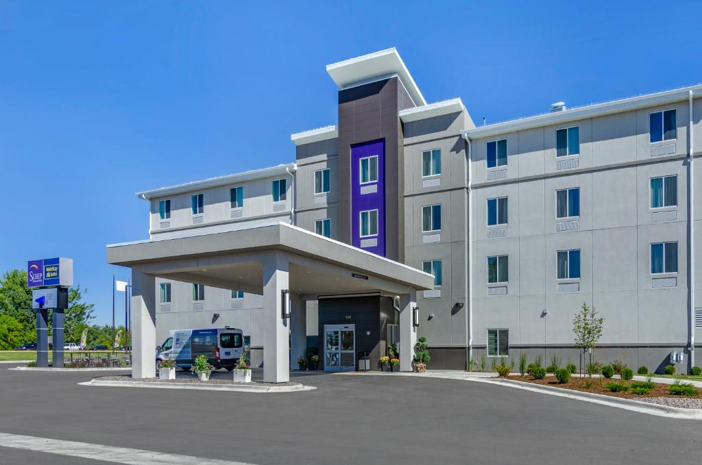 un gran edificio con un estacionamiento delante de él en MainStay Suites Great Falls Airport en Great Falls