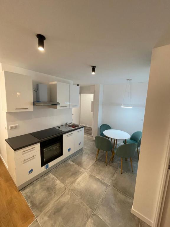 a kitchen and dining room with a table and chairs at Spacieux appartement Paris/Stade De France/CDG in La Courneuve