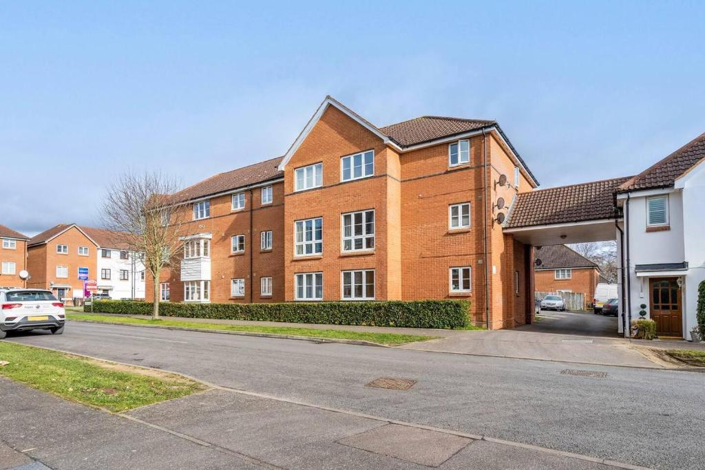 韋林花園城的住宿－Immaculate 2-Bed Apartment in Welwyn Garden City，前面有停车位的砖砌建筑