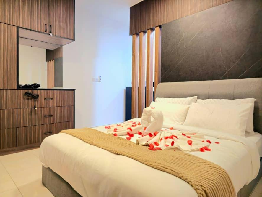 ein Schlafzimmer mit einem großen Bett mit roten Rosen darauf in der Unterkunft Tiara Imperio Studio 酒店风格与阳台泳池美景 in Bangi