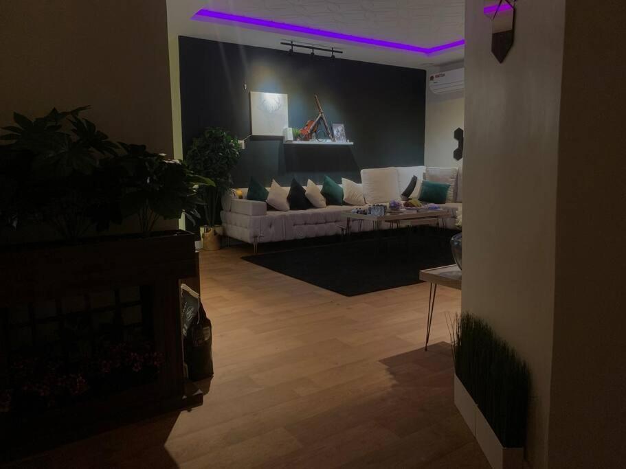 un salon avec des lumières violettes au plafond dans l'établissement شقه انيقه وموقع مميز, à Dammam