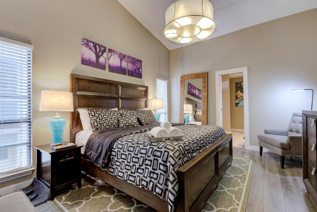 een slaapkamer met een groot bed en een stoel bij Tower Point - A Birdy Vacation Rental in San Antonio
