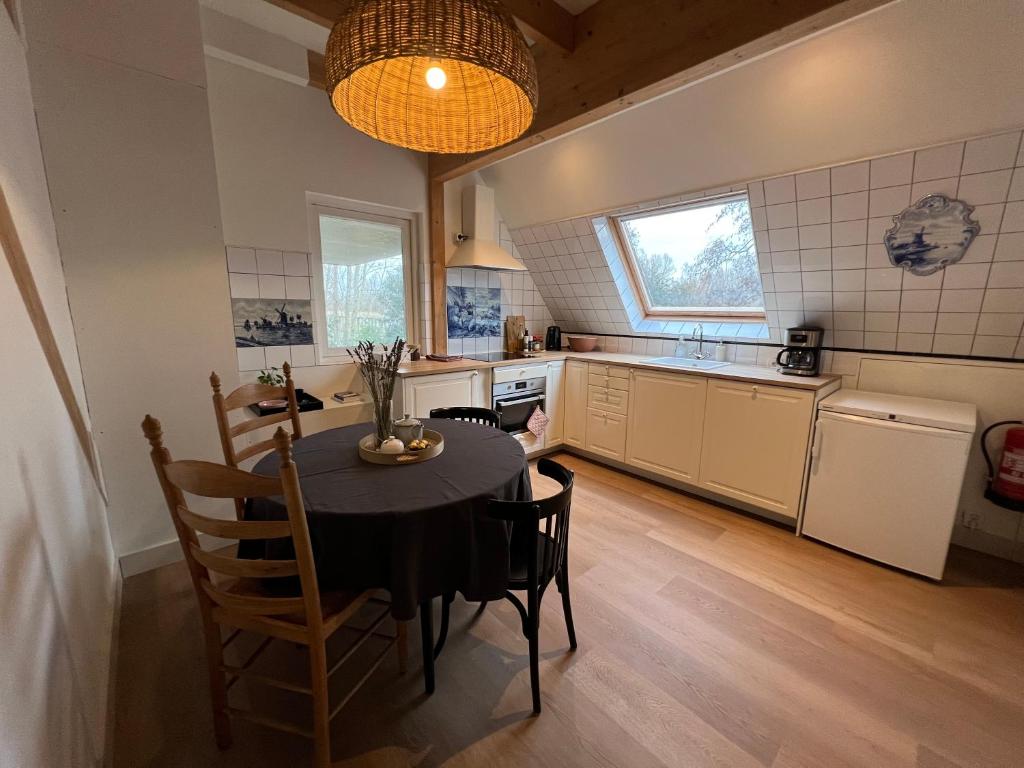 een keuken met een tafel en stoelen in een kamer bij Inn Het Nest in Amsterdam