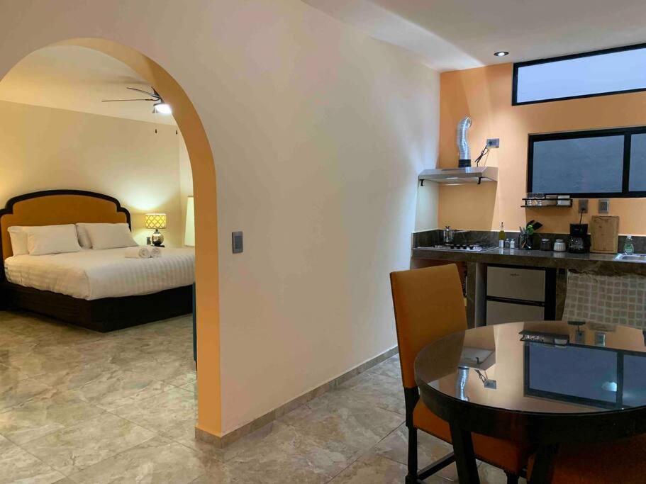 1 dormitorio con cama, mesa y comedor en Tres Iguanas Apart Hotel - New, cozy & spacious flats, short walk to beach en Loreto