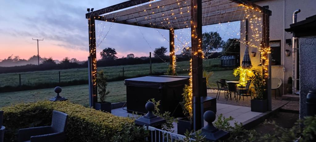 a patio with a gazebo with lights at Greenbrae's Apartment- Bushmills in Billy