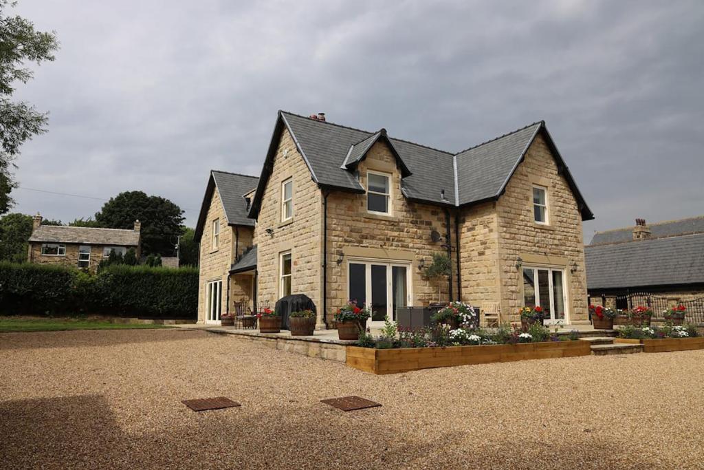 a brick house with a black roof at Bridge House Farm in Weeton