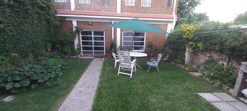 un patio con tavolo, sedie e ombrellone di Green House.river a Rosario