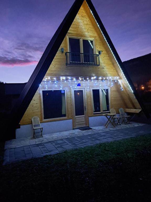 a house with lights on the side of it at night at Holiday Home Ella - Apartman Ella in Mokra Gora