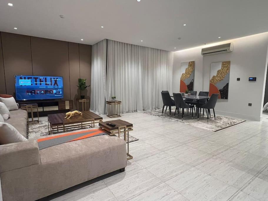 شقة فاخرة جديدة في الملقا Luxury في الرياض: غرفة معيشة مع أريكة وغرفة طعام