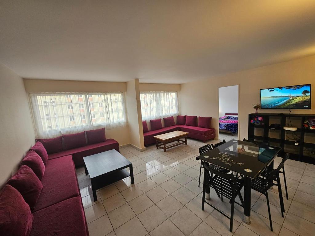 a living room with red couches and a tv at Grand appartement 160m2 equipped for professionnal groups in Sarcelles