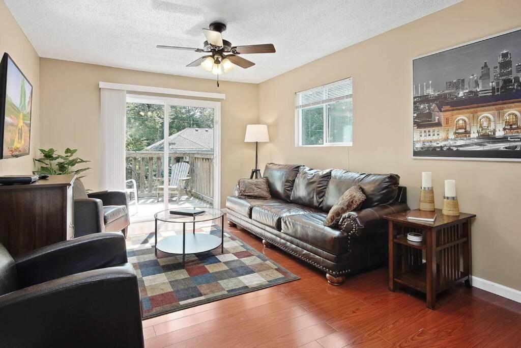 a living room with a leather couch and a ceiling fan at Overland Park ( I 35, Hwy. 69, and 87 th St. ) in Overland Park