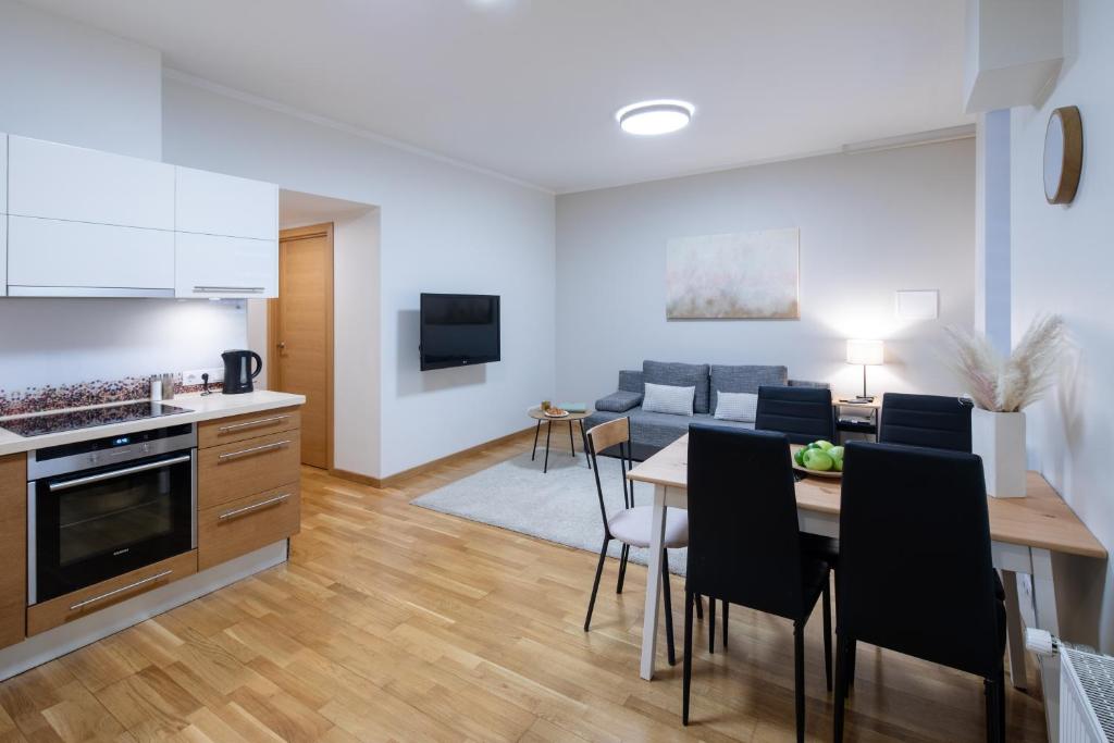 a kitchen and living room with a table and chairs at Riga Embassy center Apartment with parking in Rīga