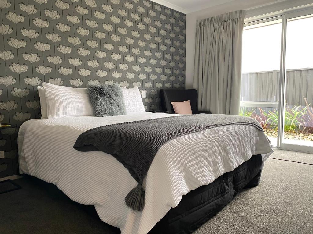 a bedroom with a bed with a floral wall at Lakeview Terrace Accommodation in Cromwell