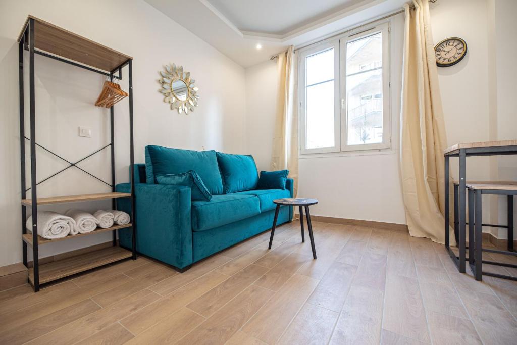 un salon avec un canapé bleu et une fenêtre dans l'établissement Cosy apartment in Paris, à Paris