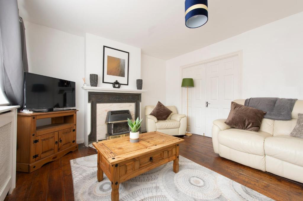 a living room with a couch and a coffee table at Chingford charm great for families and contractors in Ponders End