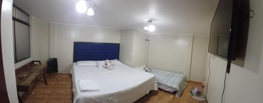 a bedroom with a white bed and a television at HOME BLESSED II in Lima