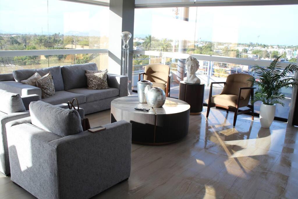 sala de estar con sofás, mesa y sillas en Departamento entero de lujo, en Los Mochis