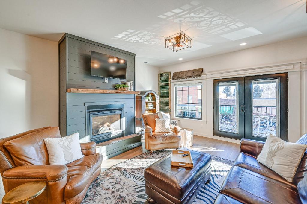 a living room with leather furniture and a fireplace at Stellar Craig Apartment - Walk to Restaurants! in Craig