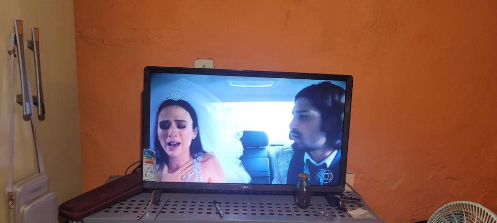 a laptop computer with a man and a woman on it at Casa grande sossego in Contagem