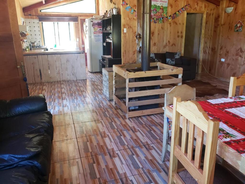 uma cozinha e uma sala de estar com piso em madeira em Cabañas Rogelio em Liquiñe