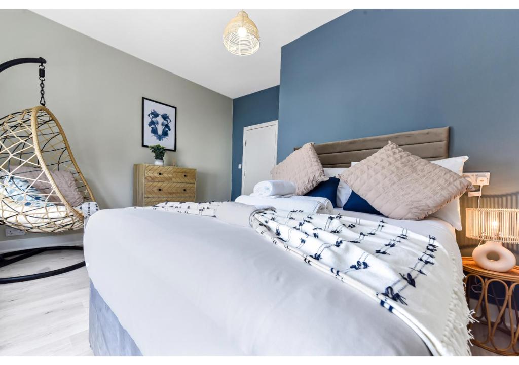 a bedroom with a large white bed with a blue wall at GREAT 4BR House in London