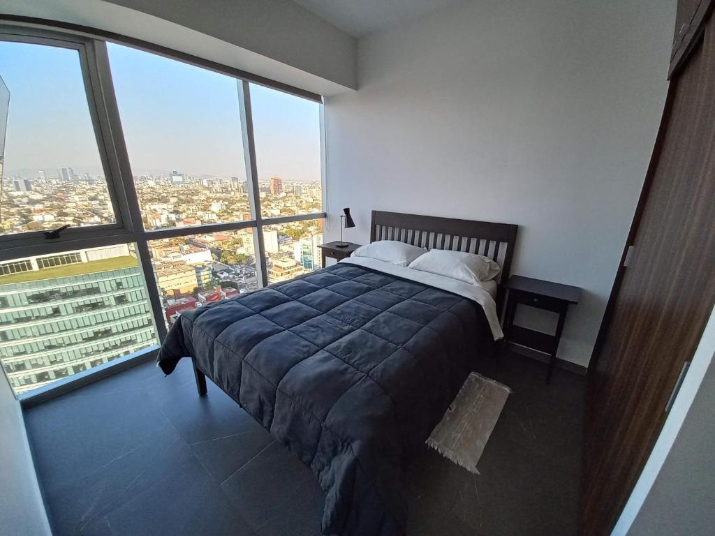 a bedroom with a bed and a large window at NSI Anseli in Mexico City