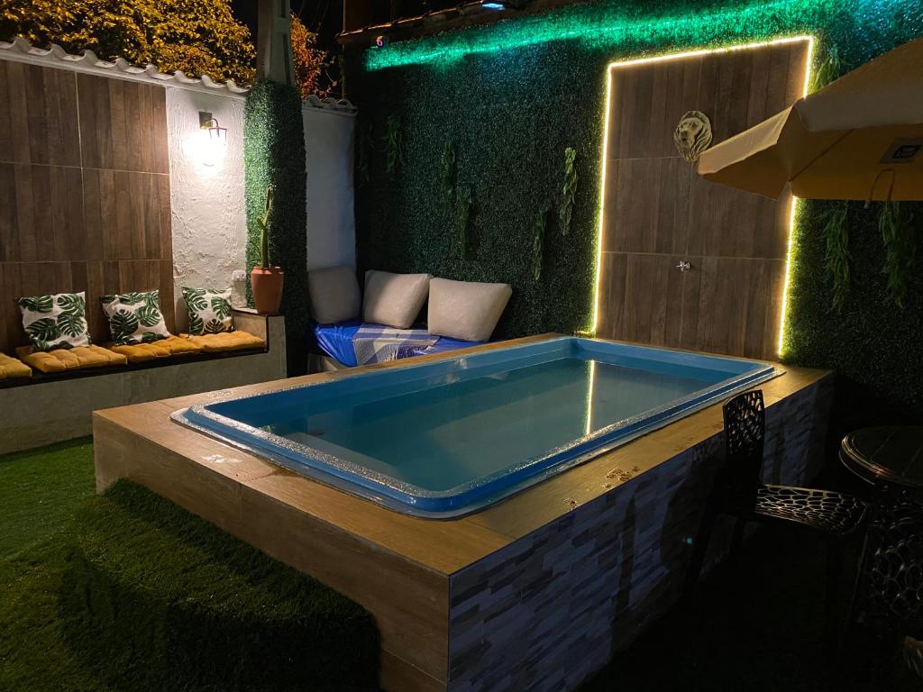 eine Whirlpool-Badewanne in einem Zimmer mit grünen Wänden in der Unterkunft Pousada do ES Rochat Maresias in Maresias