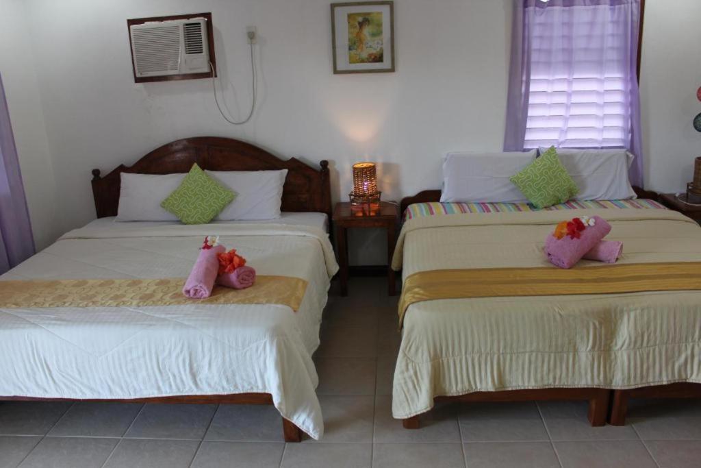 a bedroom with two beds with stuffed animals on them at Bonita Oasis Beach Resort in Moalboal