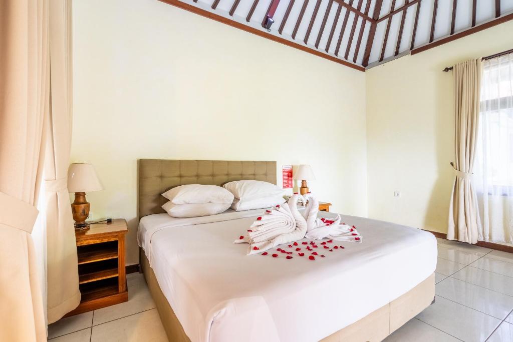 Postel nebo postele na pokoji v ubytování Taman Surgawi Resort & Spa