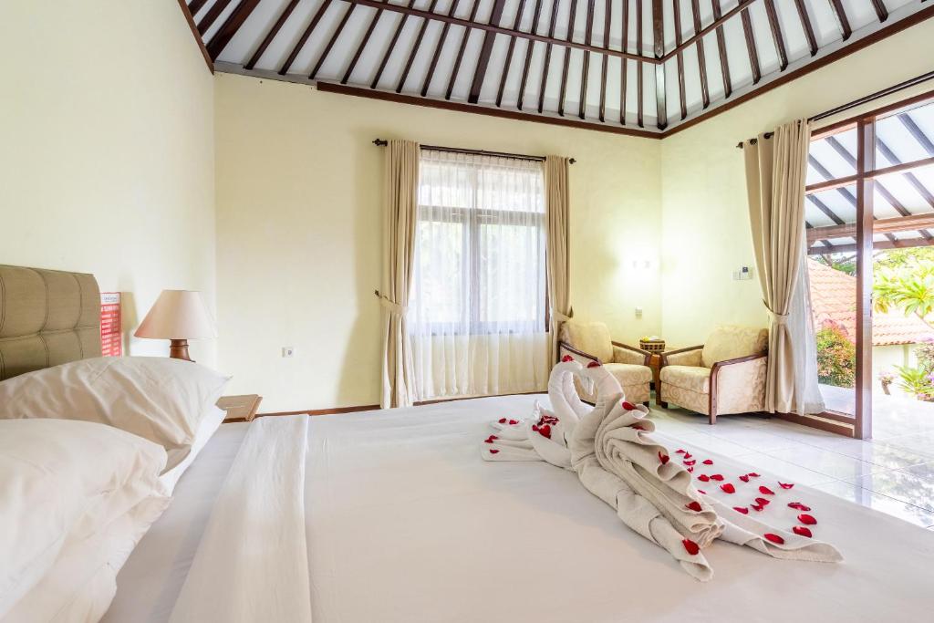 Postel nebo postele na pokoji v ubytování Taman Surgawi Resort & Spa