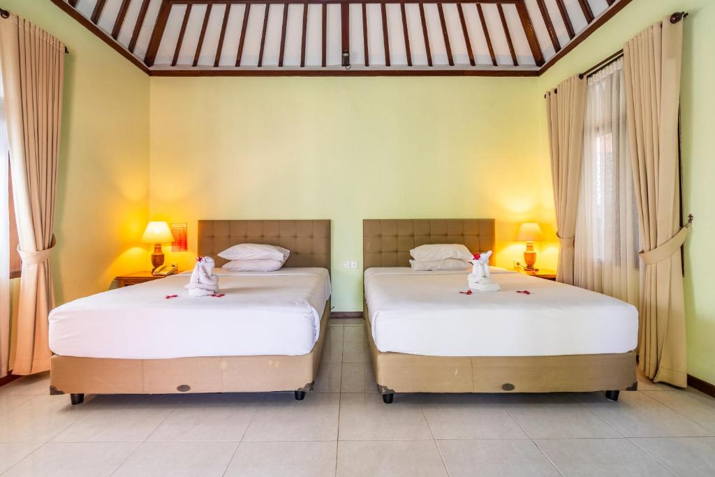 Postel nebo postele na pokoji v ubytování Taman Surgawi Resort & Spa