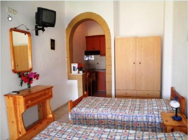a room with a bedroom with a bed and a mirror at Studios Irene in Skala