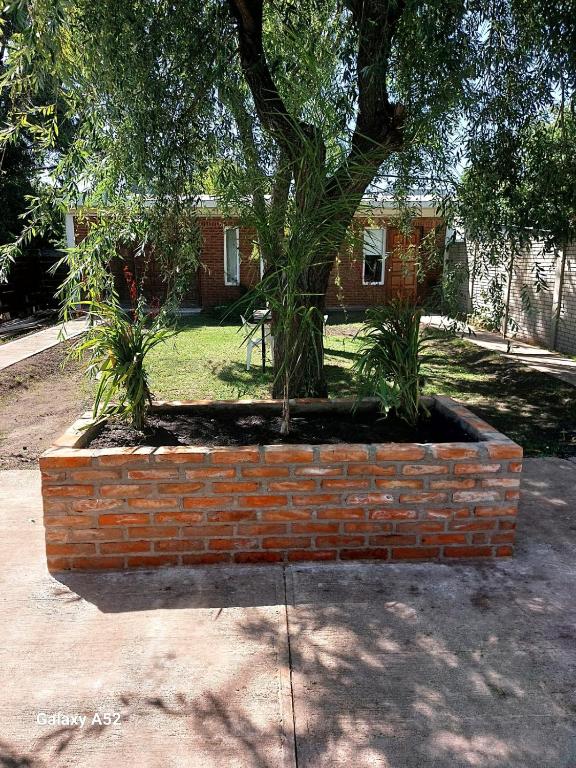 un planteur de briques avec un arbre devant une maison dans l'établissement Complejo Turismo Salvaje, à Santa Clara del Mar