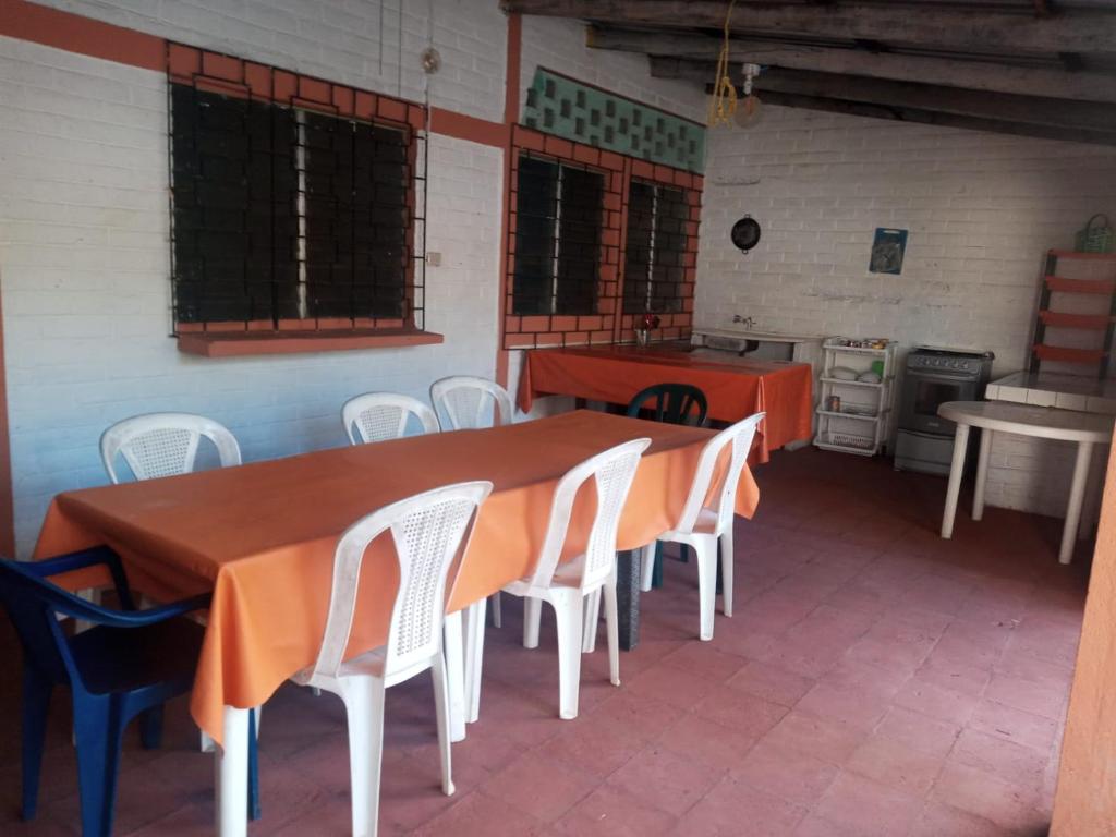 a dining room with a table and chairs and a kitchen at Rancho santa cecilia in Sonsonate