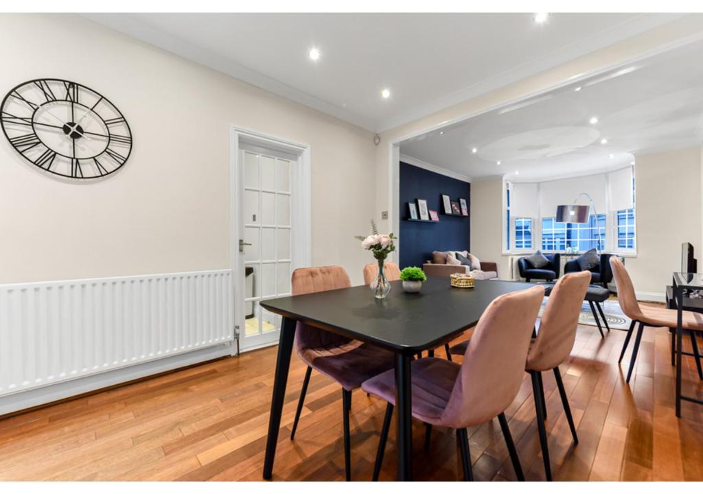 Un comedor y una sala de estar con mesa y sillas. en Homey and Pleasant 3BD, en Londres