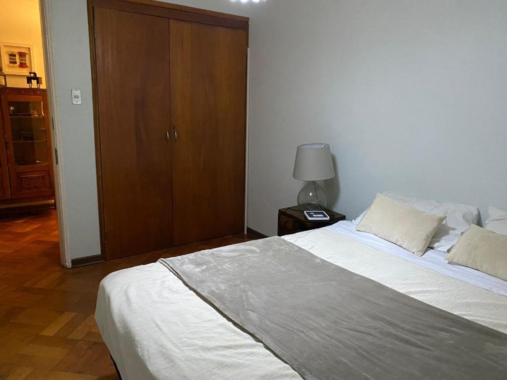 ein Schlafzimmer mit einem großen Bett und einem Holzschrank in der Unterkunft BBCasita Las Condes in Santiago