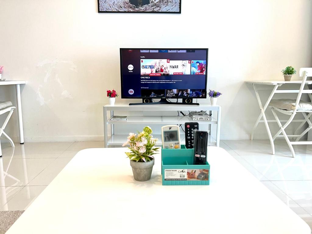 a living room with a television on a white table at Summer suites KLCC by cozy stay in Kuala Lumpur