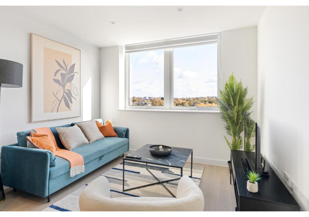 uma sala de estar com um sofá azul e uma mesa em Beckenham Beauty: Modern 1-Bedroom Abode em Beckenham