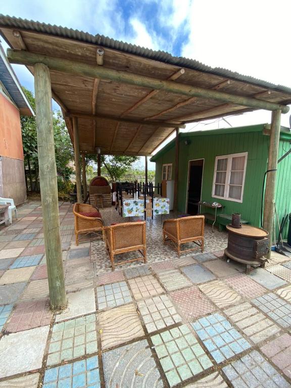 eine Terrasse mit Stühlen und einer hölzernen Pergola in der Unterkunft CABAÑA EL QUISCO in El Quisco