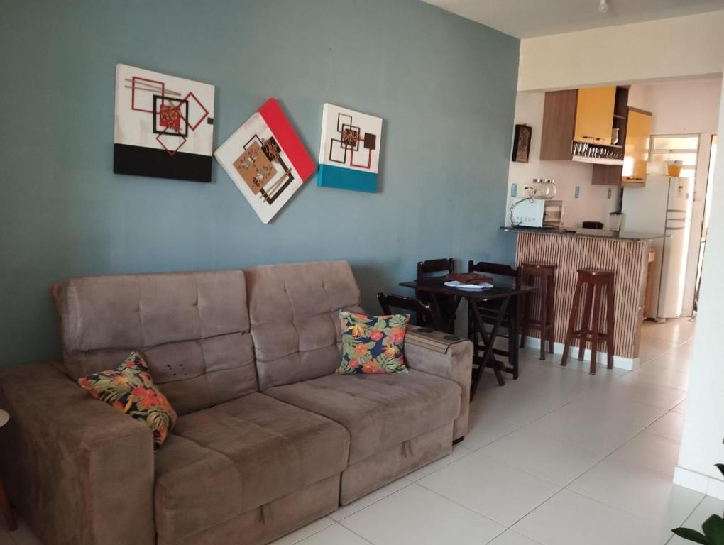 uma sala de estar com um sofá castanho e uma cozinha em Recanto Casa SOL em Barra de Jacuípe