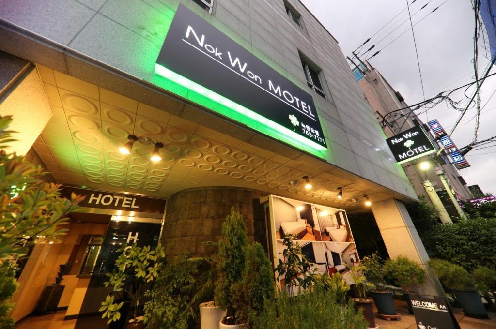 un hotel con un cartel en la parte delantera en Nokwon Motel en Jeju