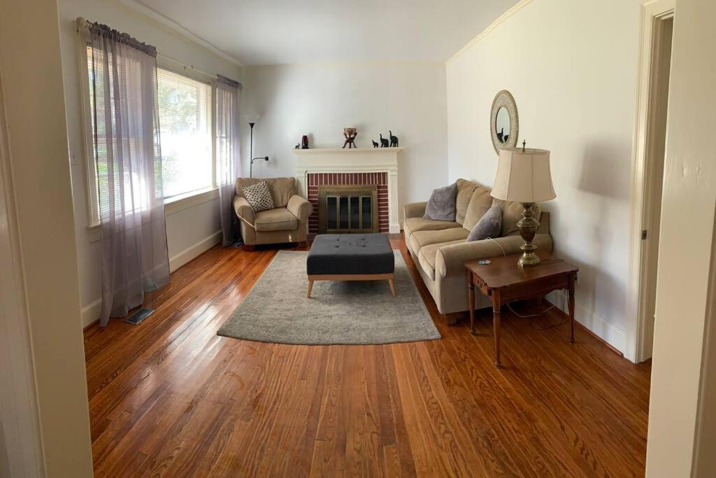 ein Wohnzimmer mit einem Sofa und einem Kamin in der Unterkunft Cozy Brick House Mins to Hospital in Goldsboro