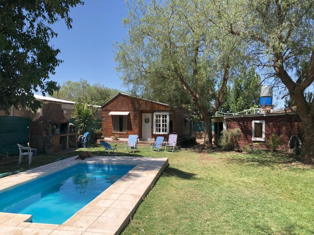 un patio trasero con piscina y una casa en Cabaña Terra Calma en Vistalba