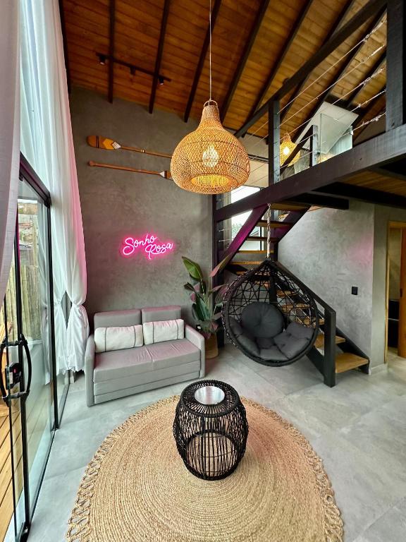 a living room with a couch and a large rug at Cabanas Sonho Rosa - com banheira hidro e cesta de café cortesia na primeira manhã in Imbituba